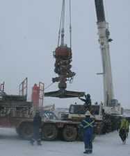 photo of workers outside using a crane with snow on the ground