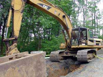 The track-hoe involved in this incident was pulling a trench shield forward in a trench for a sewer system when a hook failed and the rigging snapped loose.