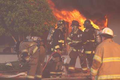 Fire fighters in front of burning building