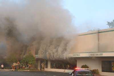 Smoke rolling from the front of the building as the windows are being knocked out.