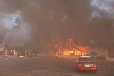 Fire pouring out of the broken windows in front of the store