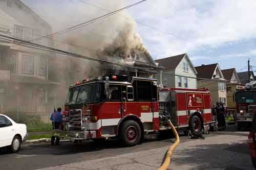 dense smoke from both the roof and eaves