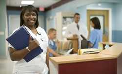 A nurse in a hospital smiles at the camera