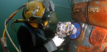 commercial diver repairing a boat under water