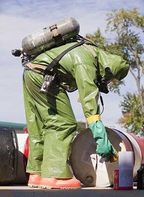 HazMat firefighter using sensing meter for examining gas levels