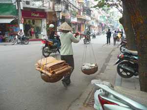 	Woman carrying supplies on her shoulders 