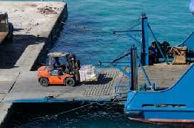 man using a forklift to place a large load 