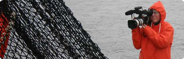 	An image of a videographer filming the operations on board a commercial salmon vessel in Puget Sound.