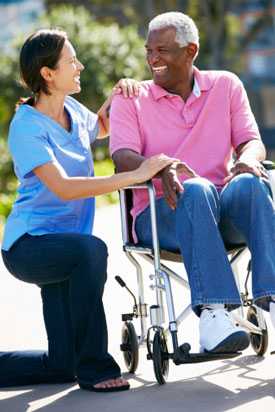 	Caretaker helping elderly man in wheelchair.