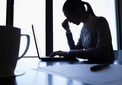 	Woman in front of laptop resting her eyes.