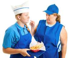 	A manager points her finger at a frightened young woman worker holding a basket of French fries. 