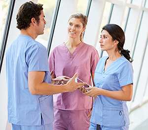 three nurses talking in hallway