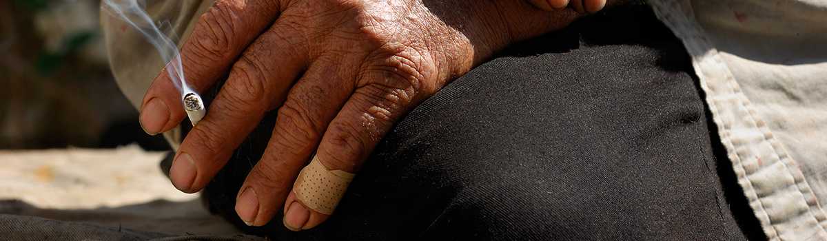 	male hand holding a cigarette