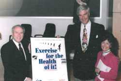 Dan Goldin, Tom McMillen, and Catherine Angotti pose with the signed poster