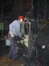 	a worker wears hearing protection as he operates heavy machinery