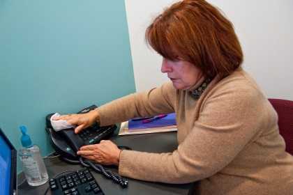 Woman at work cleaning her phone.