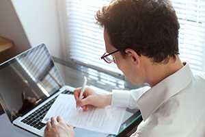 Businessman working with documents on laptop