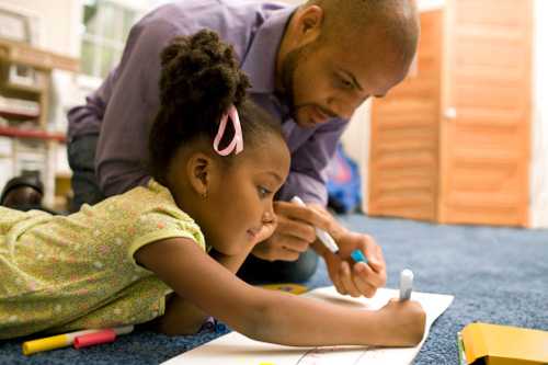 Dad and daughter on the floor coloring