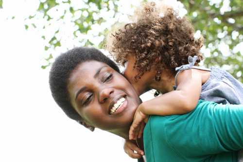 Young girl riding on mom's back