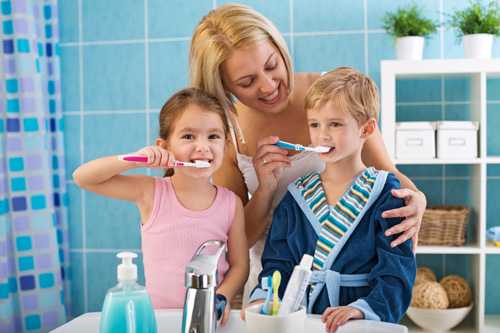 Mom watching kids brush teeth