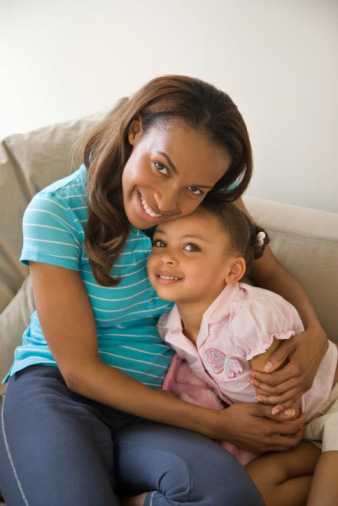 Mom sitting in chair hugging daughter