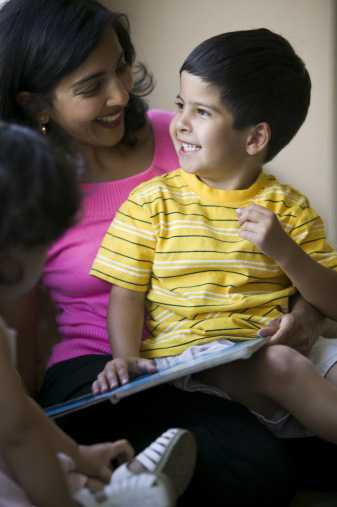 Mom with son sitting in her lap with a book