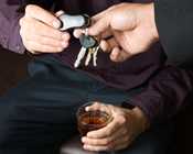 photo: man holding a drink handing over his keys