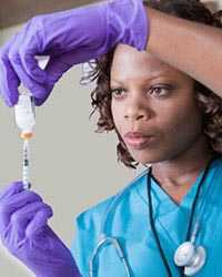 Nurse with syringe and vial of medicine.