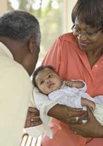 Foto de abuelos cargando a un bebé.