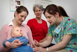 This infant was receiving an intramuscular immunization in his left thigh muscle, which was being administered nurse