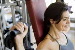 a young woman using weights at the gym.