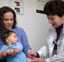 doctor giving vaccine to child in mother's lap