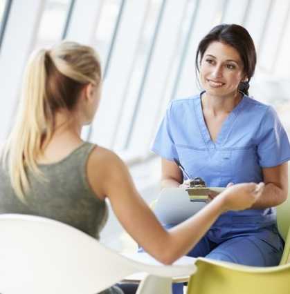 A young woman speaking with her nurse