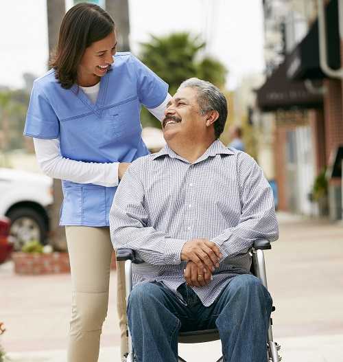 Image of a nurse pushing a patient in his wheelchair