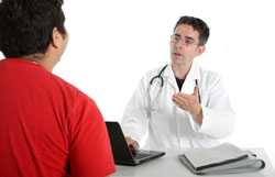 Doctor sitting at his desk talking with a patient