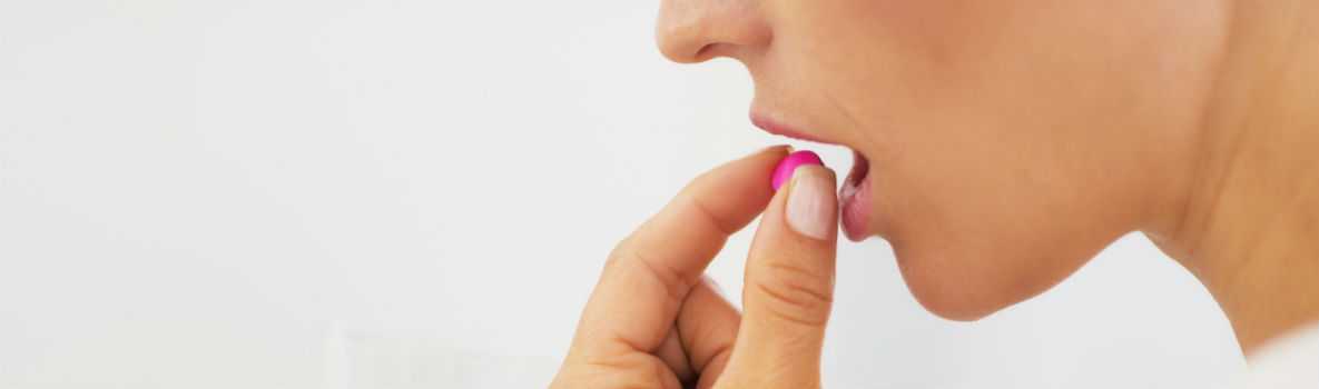  Woman taking pill with glass of water