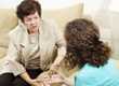 Two women sitting on couches and having a conversation as if one is being counseled