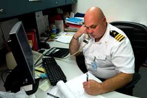 A plublic health officer on the phone and writing in a notepad.