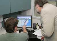 Two men in an office looking at a computer screen