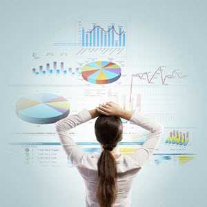 a woman looking at a number of charts on the wall