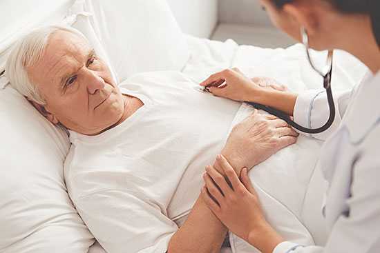 Male doctor conversing with senior male patient