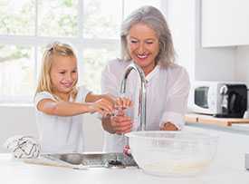 Grandmother and granddaughter washing their hands.