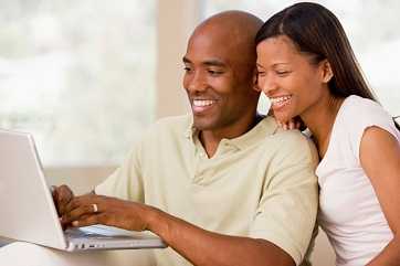 A couple looking at a laptop screen.