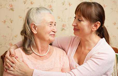 Mujer adulta abrazando a su madre de mayor edad. 