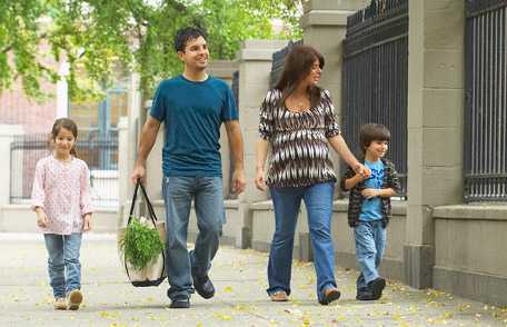 Familia camina junta en la vereda. 