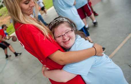 Una atleta de las Olimpiadas Especiales abraza a un ser querido.