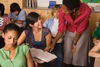 Foto: Maestra hablando con sus alumnos en un salón de clases