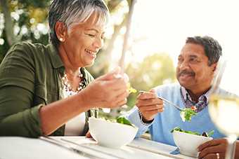 Couple eating salad outside