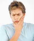 Boy holding jaw in pain