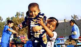 Niña sonriendo con un bebé